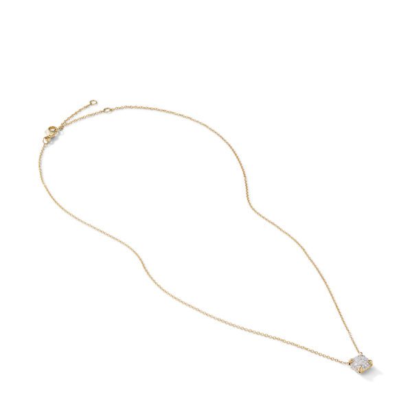 A delicate gold necklace with a fine chain and a small, sparkling pendant featuring a square-cut gemstone. The chain has an adjustable clasp. The elegant design highlights the simplicity and brilliance of the single, prominent stone.