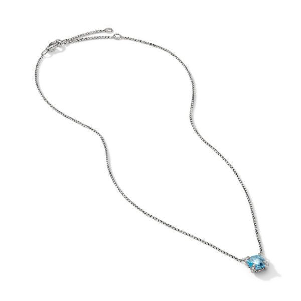 A delicate silver chain necklace featuring a single blue gemstone pendant. The chain has an adjustable clasp and the blue gemstone is set in a simple, elegant metal setting, standing out as the focal point of the necklace against the white background.