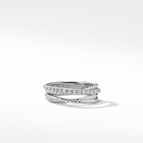 A silver ring comprised of three intertwined bands is displayed against a plain white background. One band is encrusted with small diamonds, adding a touch of sparkle to the sleek and elegant design. Shadows beneath the ring enhance its three-dimensional appearance.