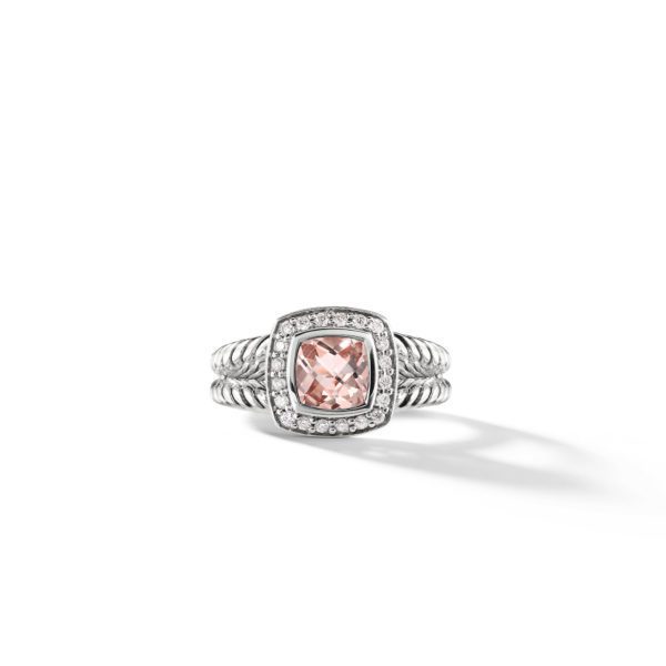 A silver ring with a twisted band design features a large, rectangular pink gemstone at its center. The gemstone is surrounded by a border of small, sparkling diamonds set into the metal.