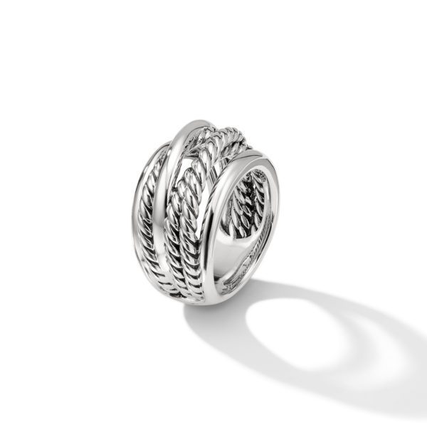 A shiny silver ring featuring a design of multiple intertwined strands, some with a rope-like texture. The ring casts a shadow on a white background, highlighting its intricate details.