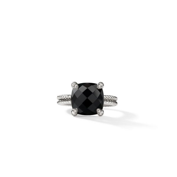 A close-up image of an elegant ring featuring a large, square black gemstone with a faceted surface. The gemstone is set in a sleek silver band with intricate twisted detailing, and four small silver prongs secure the stone in place.