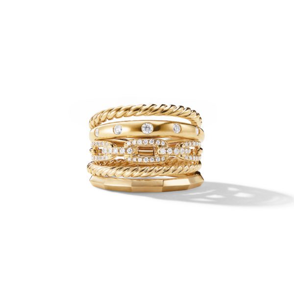 A luxurious gold ring composed of multiple stacked bands. Each band features a unique design, including twisted rope patterns and diamond accents. The ring exhibits intricate craftsmanship and a radiant shine, set against a white background.