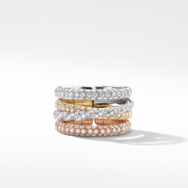 A stack of three elegant diamond rings in a spiral design, featuring different gold tones: white gold on top, yellow gold in the middle, and rose gold on the bottom. The rings are set with small, sparkling diamonds and are displayed against a white background.