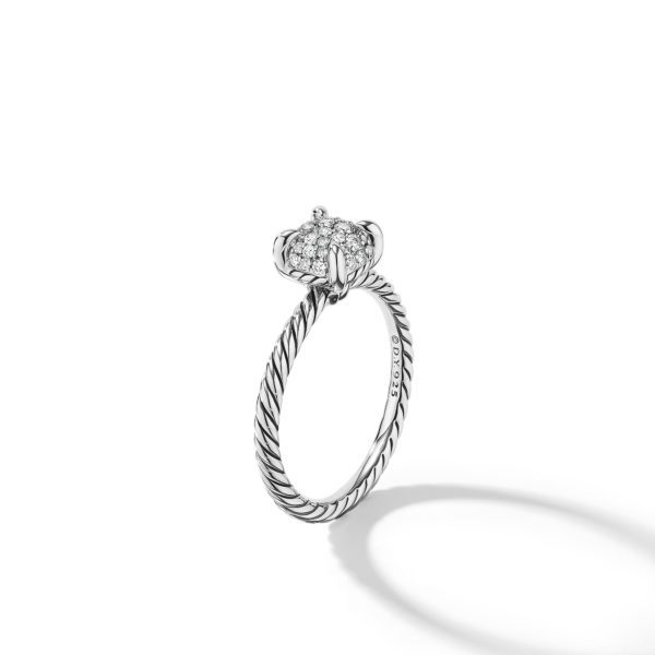 A close-up of an elegant silver ring with a twisted band design. The ring features a cluster of small, sparkling diamonds set in a circular shape at the top. The image is set against a white background with the ring casting a faint shadow.