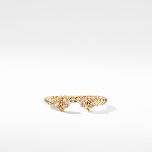 A gold twisted cable cuff bracelet with four diamond-accented end caps, each end featuring two small diamonds set in a circular arrangement. The bracelet is displayed against a plain, light grey background.