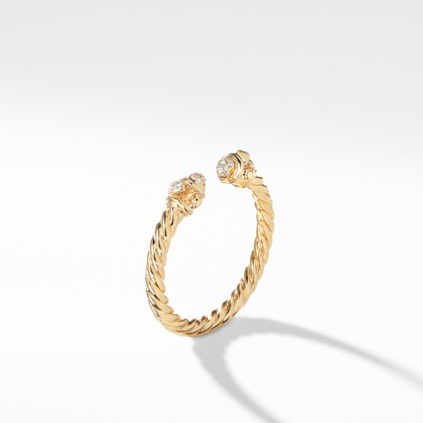 A gold bracelet with a twisted rope design, featuring two embellished end caps each adorned with a small, clear gemstone. The bracelet is displayed on a plain white background, casting a subtle shadow.