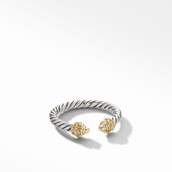 A twisted silver bracelet featuring gold accents and diamond embellishments at both ends. The bracelet is displayed against a plain white background, highlighting its intricate design and elegant craftsmanship.