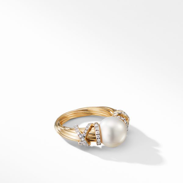 A gold ring featuring a large, round pearl in the center, adorned with crisscrossing bands studded with small diamonds. The ring is set against a white background with a soft shadow.