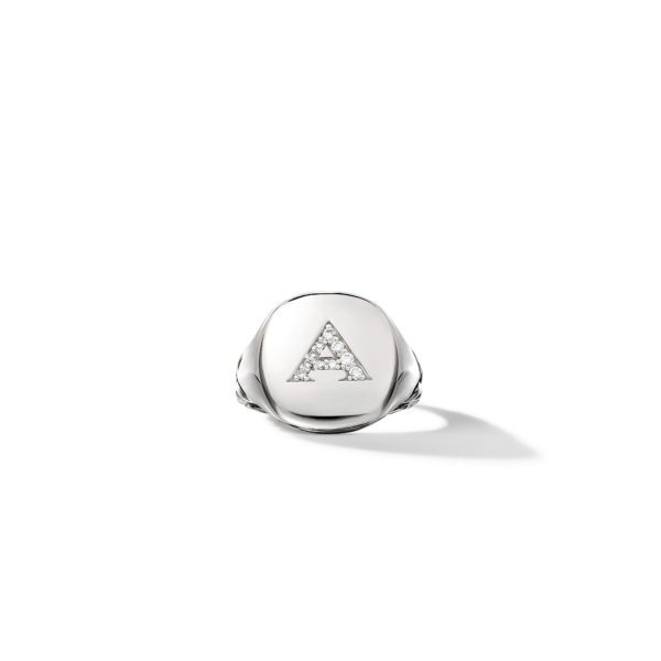 A silver ring with a flat top inscribed with a triangular letter "A" inlaid with small, sparkling diamonds. The ring is positioned upright against a white background, casting a soft shadow to the right.