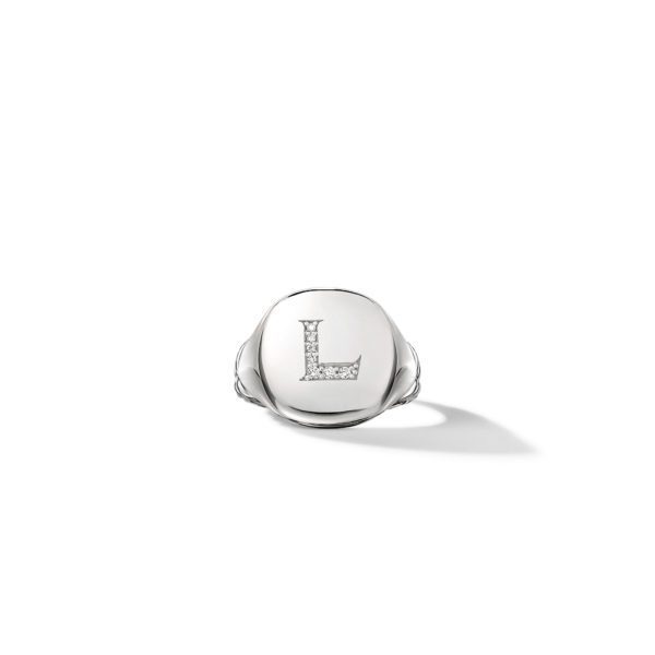 A silver ring with a wide, round face featuring the letter "L" engraved in capital letters. The engraving is adorned with small, sparkling stones. The ring is shown on a white background with a slight shadow.