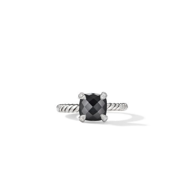 A silver ring featuring a large, square-cut black gemstone held by four prongs, each adorned with a small white diamond. The band has a twisted rope design. The ring is displayed against a plain white background.