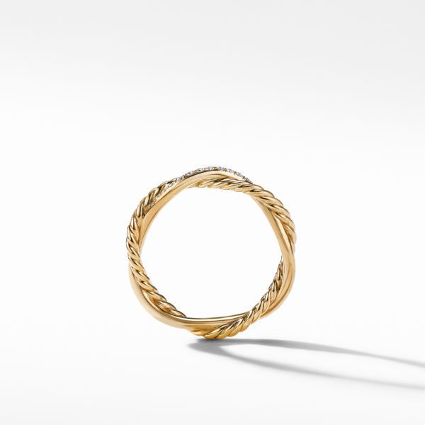 A gold ring with a twisted, rope-like design is shown against a white background. The ring casts a faint shadow on the surface below it.