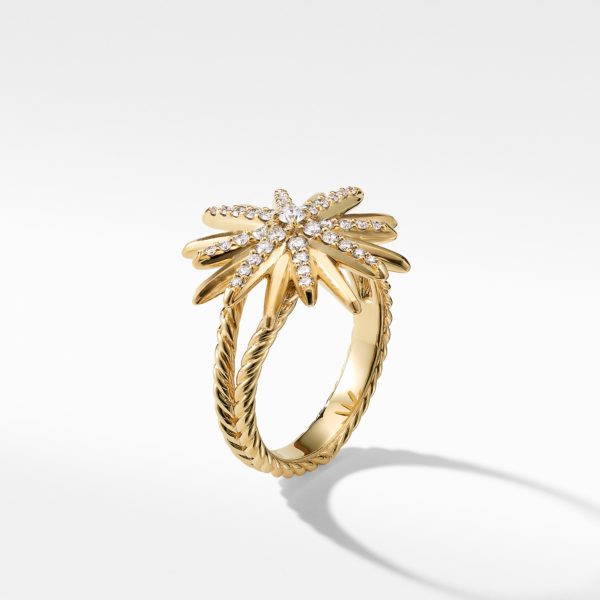 A gold ring features a palm tree design enriched with small, sparkling diamonds. The band is twisted, adding texture and style, and the entire ring casts a subtle shadow on the white background. The overall look is elegant and luxurious.