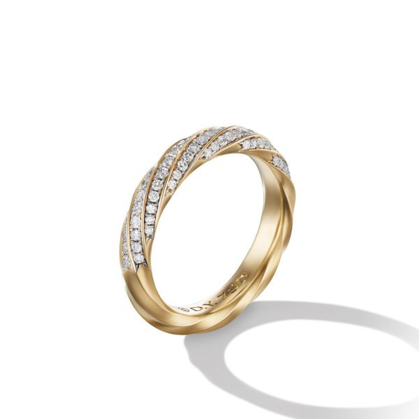 A gold ring with an intricate twisted design, adorned with rows of small, sparkling diamonds. The ring casts a soft shadow on a white background, emphasizing its elegant and luxurious appearance.