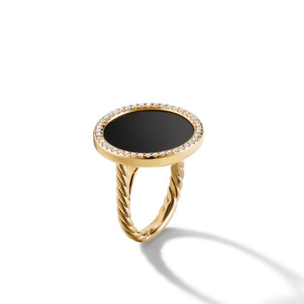 A gold ring with a twisted band features a circular black onyx centerpiece surrounded by a border of small, sparkling diamonds. The ring is displayed against a white background, casting a faint shadow.