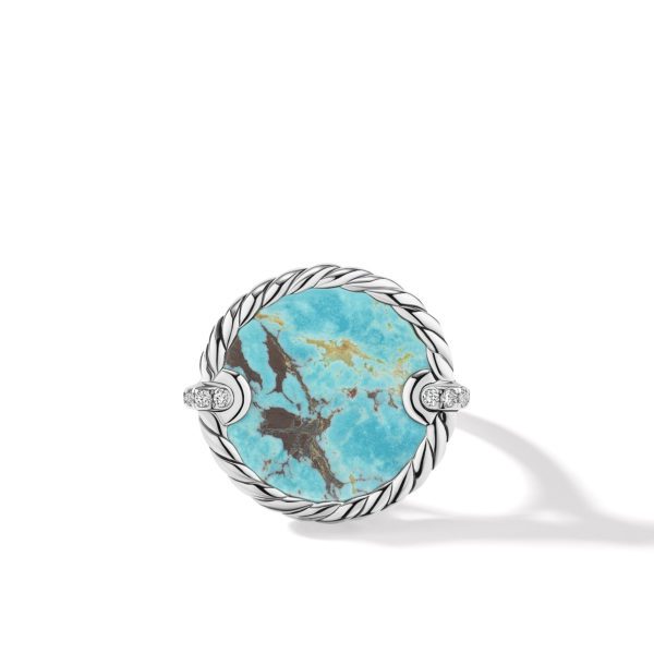 A ring featuring a large round turquoise stone with natural brown veining, set in a silver band with a rope-like texture design. The band has two small clusters of white stones on either side of the turquoise. The ring casts a soft shadow on a white background.