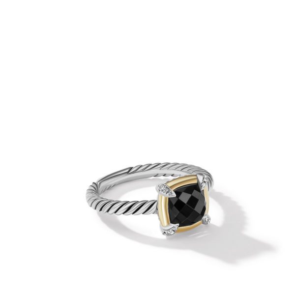 A silver ring with a twisted band design featuring a square black gemstone held by four prongs with small diamonds. The setting has a gold-toned border around the gemstone. The ring casts a shadow on a white background.