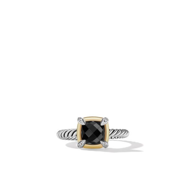 A silver ring with a twisted band features a large black, faceted square stone set in a gold bezel. The stone is secured by four silver prongs, each adorned with a small diamond. The ring is displayed on a clean, white background.