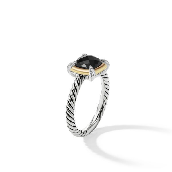 A stylish ring featuring a black faceted gemstone mounted with silver and gold accents. The band has an elegant twisted rope design. The ring is displayed on a white background with its shadow visible.