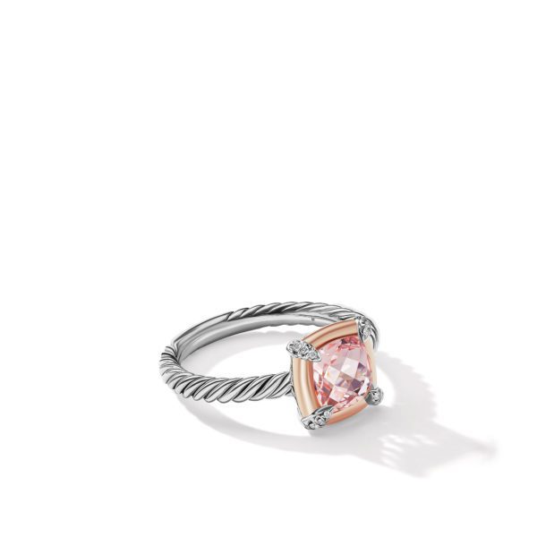 A silver ring featuring a twisted band design and a cushion-cut pink gemstone set in a delicate prong setting, adorned with small white accent stones at each corner of the central gemstone. The ring casts a subtle shadow on the white background.