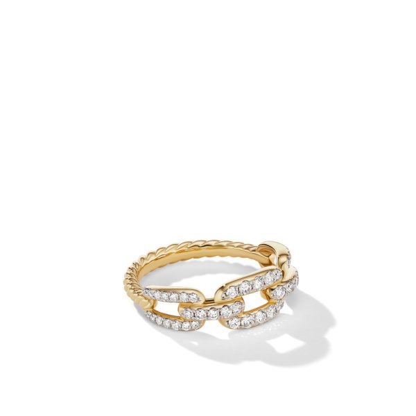 A gold ring featuring a chain-link design adorned with sparkling diamonds. The ring has a delicate twisted band and the central part of the chain links is encrusted with small, glittering stones. The ring casts a slight shadow against a white background.