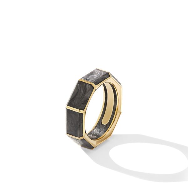 A gold octagonal ring with black marbled inlays sits upright on a white background. Its reflection casts a soft shadow below.