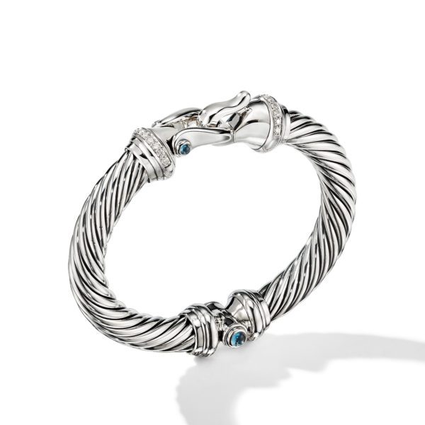 A twisted silver bracelet adorned with small blue gemstones and diamond accents, featuring a clasp designed like two animal heads facing each other. The bracelet has a sleek, elegant design with a polished finish.