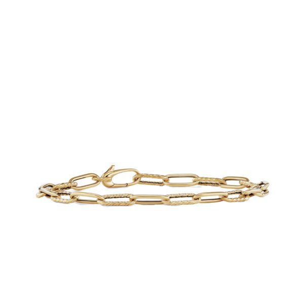 A delicate gold chain bracelet with interlocking oval links, featuring a lobster clasp closure. The design includes several textured links that enhance its elegant appearance. The bracelet lies flat against a plain white background.