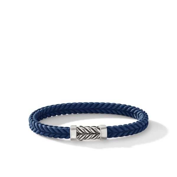 A blue braided bracelet with a silver cylindrical clasp that features an intricate, diagonal striped design. The design of the bracelet is simple and elegant, resting on a white background.