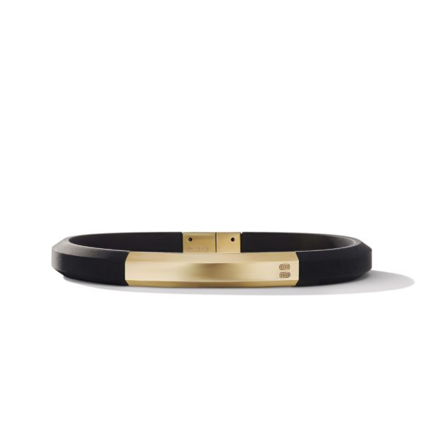 A minimalist, black bracelet with a sleek gold clasp and accent piece in the center, displayed on a white background. The bracelet has a modern, unisex design with clean lines and a simple yet elegant appearance.