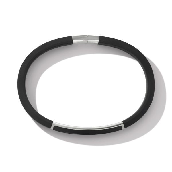 A round, black fitness tracker wristband with a metallic clasp and a sleek, minimalist design placed against a white background. The shadow under the band suggests natural lighting from above.