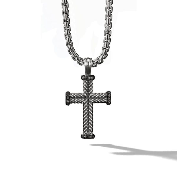 A silver cross pendant with a textured, rope-like design hangs from a thick, matching chain. The pendant casts a shadow against a plain white background.