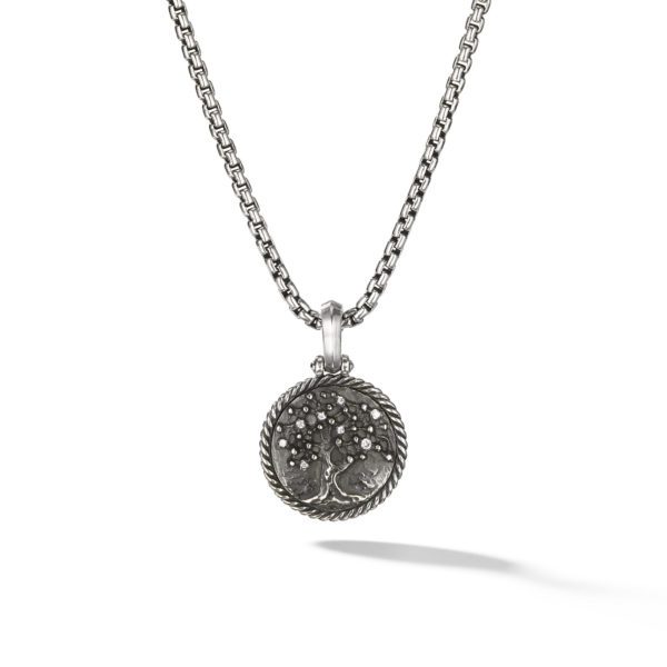 A silver necklace with a circular pendant featuring a raised tree design in the center. The pendant has a braided rope-like border and hangs from a medium-width chain with a box link pattern. The shadow of the pendant is visible underneath.