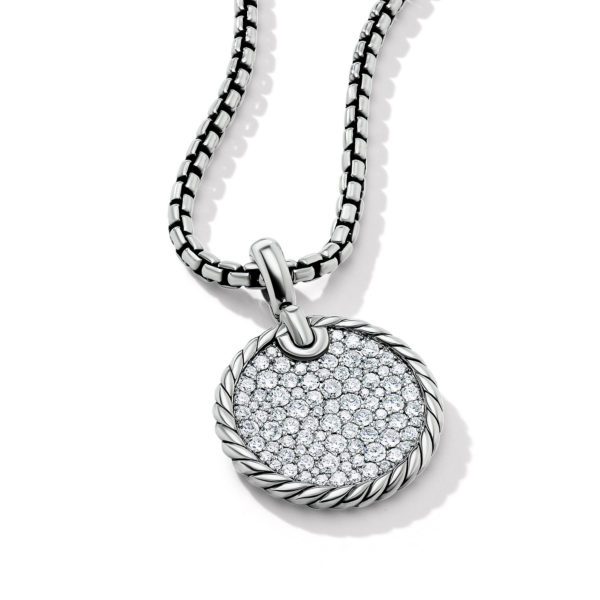 A silver necklace features a round pendant encrusted with numerous small, sparkling diamonds. The pendant has a rope-like textured border and hangs on a chain with interlocking rectangular links. The jewelry is displayed on a white background.