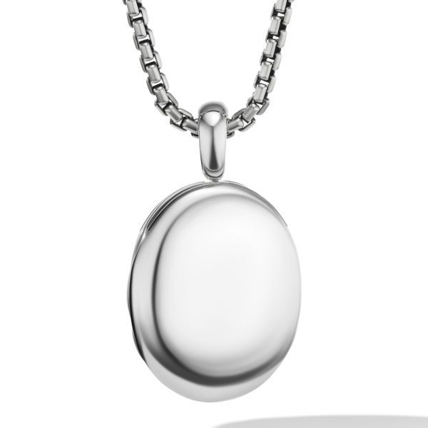 A close-up image of a sleek, oval-shaped silver locket hanging from a thick, metallic chain necklace. The locket has a smooth, polished surface and appears to be unopened. The chain features an interlocking, box-like design.