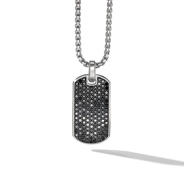 A silver dog tag pendant necklace with a hexagonal pattern design on its surface, featuring black and silver accents. The pendant hangs from a silver chain link necklace against a plain white background, casting a slight shadow.