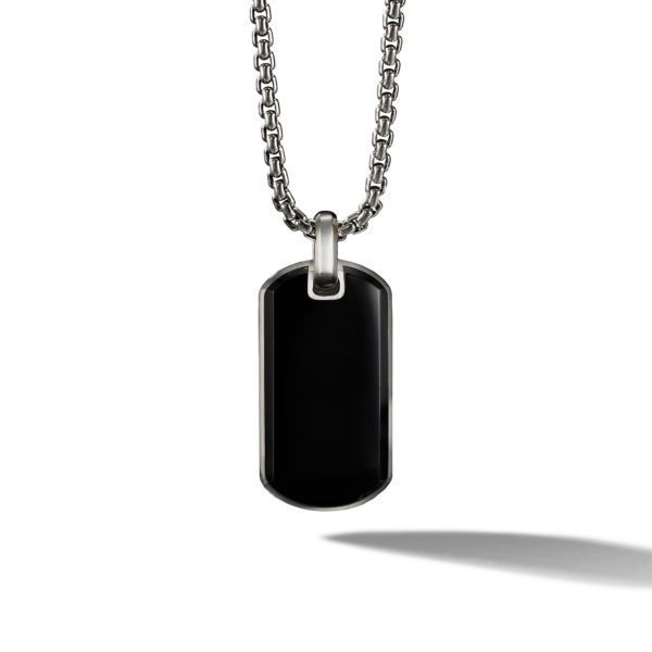 A polished black dog tag pendant hangs from a silver chain. The tag has rounded edges and a smooth, reflective surface. The necklace casts a slight shadow on a white background.