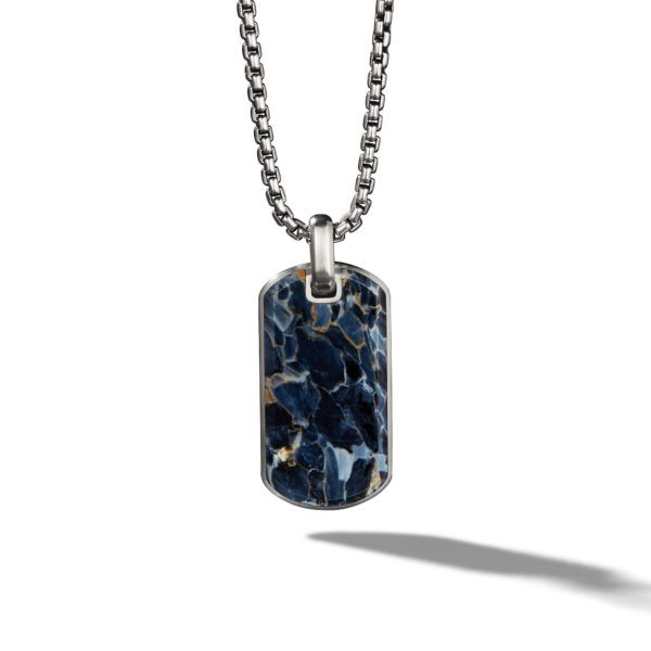 A stylish necklace featuring a rectangular pendant with a dark blue and black marbled stone design, set in a silver frame. The pendant hangs from a silver chain with a visible clasp at the top, casting a shadow on a plain white background.