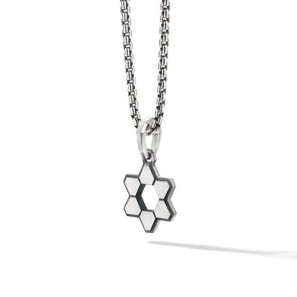 A silver necklace with a geometric hexagon pendant. The hexagon consists of six smaller hexagonal sections around a central hexagon, creating a honeycomb appearance. The necklace casts a shadow on a white background.