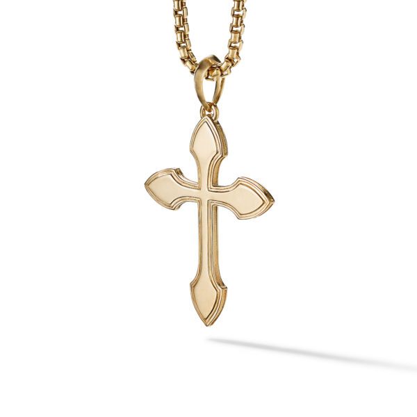 A gold cross pendant on a matching gold chain necklace. The cross has pointed ends and beveled edges, giving it a sleek and elegant appearance. The pendant and chain are set against a plain white background, casting a small shadow.