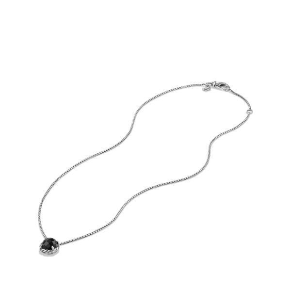 A silver chain necklace with a round, black gemstone pendant. The chain features a simple, elegant design and a lobster clasp closure. The gemstone is set in a decorative frame, adding a touch of sophistication to the necklace.