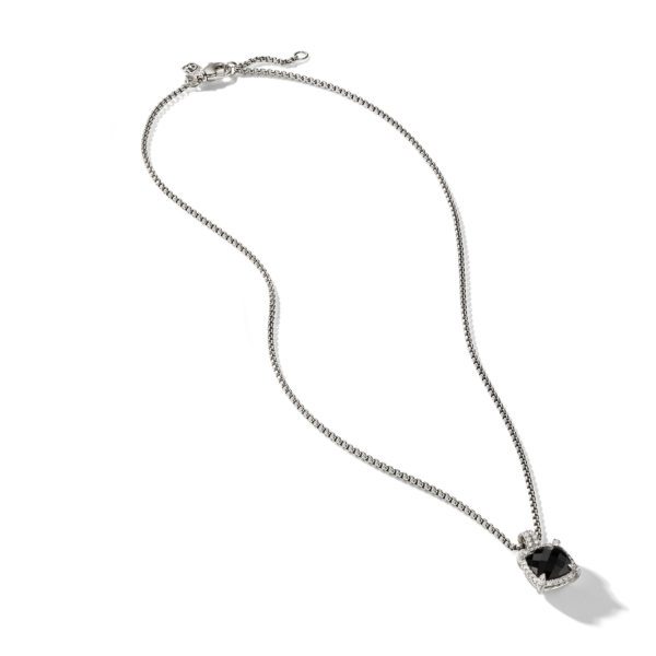 A delicate silver chain necklace featuring a square-cut black gemstone pendant in a halo setting, adorned with small clear stones around it. The necklace is laid out flat on a white background.