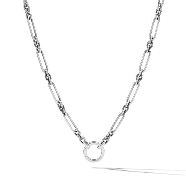 A silver chain necklace with elongated rectangular links, featuring a sleek circular pendant at the center. The necklace casts a shadow on a white background.