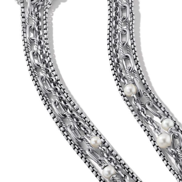 A close-up image of a silver chain necklace adorned with several white pearls interspersed along its length. The chain features an intricate interwoven pattern, and the pearls add an elegant touch to the sleek metallic design.