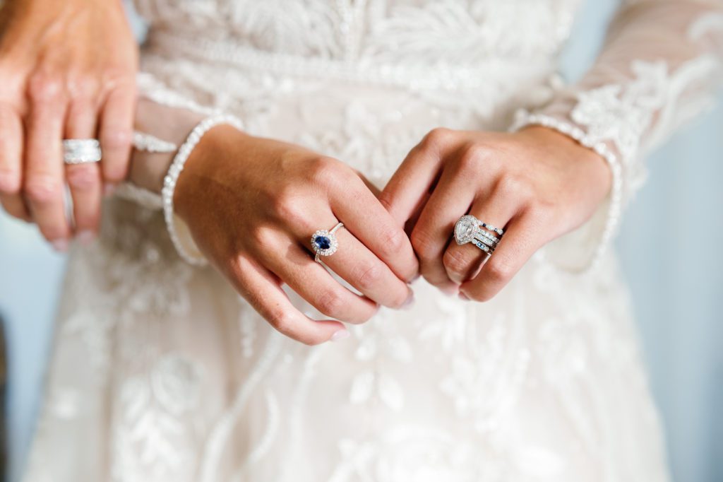Closeup of a bride’s hands. She is wearing a mixed wedding band set.