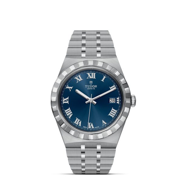 The TUDOR Royal wristwatch is displayed with a silver case and metal bracelet. It features a striking blue dial adorned with silver Roman numerals, a date window at the 3 o'clock position, and a fluted bezel. The brand name "TUDOR" and logo are positioned neatly beneath the 12 o'clock mark.