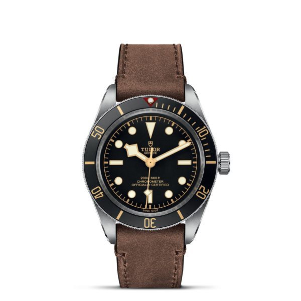 The TUDOR Black Bay Fifty-Eight wristwatch features a black dial with round hour markers and comes with a brown leather strap. Its design includes a silver case, luminous hands, and a rotating bezel marked with minute indicators.