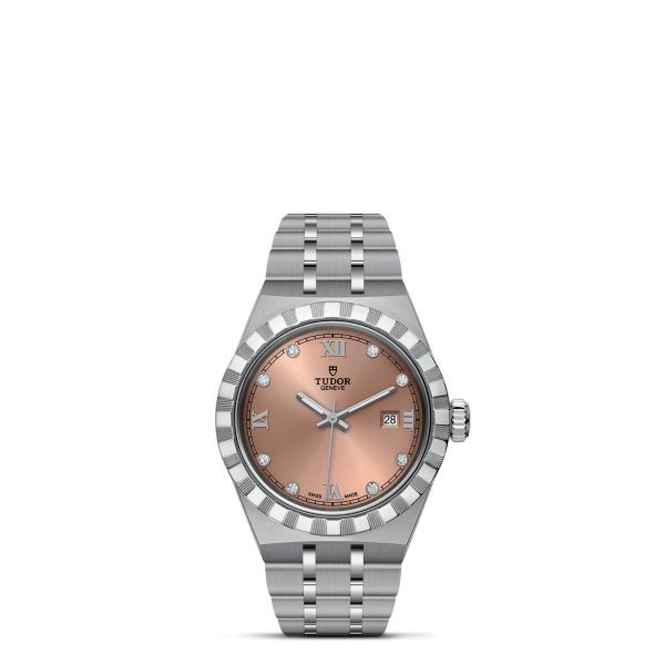 A TUDOR Royal wristwatch with a silver metal bracelet and a light pink dial. The watch features silver markers with diamonds at the 3, 6, 9, and 12 positions and a small date window at the 3 o’clock position. The bezel is fluted, adding a textured detail.