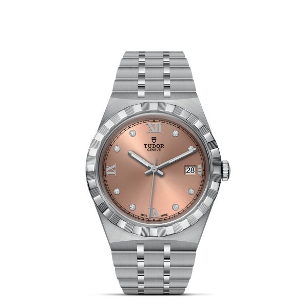 The TUDOR Royal wristwatch is a luxurious timepiece with a stainless steel band and case, featuring a pink-faced dial. The dial displays silver Roman numerals at the 12, 3, 6, and 9 o'clock positions along with diamond hour markers. Additionally, it includes a small date window at the 3 o'clock position and prominently showcases the brand name "Tudor" below the 12 o'clock mark.